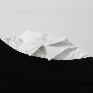 Close-up of the elegant white shirt collar and black knit sweater neckline for women.