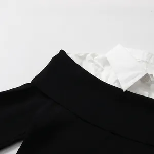 Detail of fake two-piece top with black knit neckline and white shirt collar stitching.