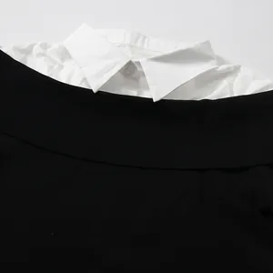 Close-up detail of white shirt collar stitched to a black off-the-shoulder knit sweater