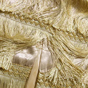 Macro detail of layered gold silk-like fringe and wave-pattern embroidery on skirt