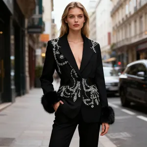 Detail of luxury black blazer featuring sparkling rhinestone patterns and elegant fur cuffs.
