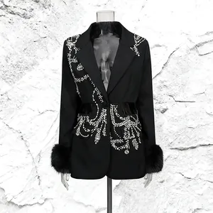 Close-up detail of luxurious black blazer featuring intricate rhinestone patterns and fur cuffs
