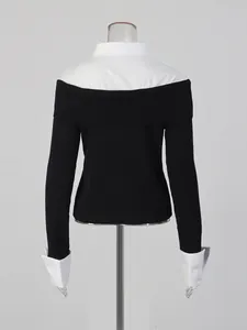 Back view of a black off-shoulder knit sweater with white shirt collar and cuffs contrast