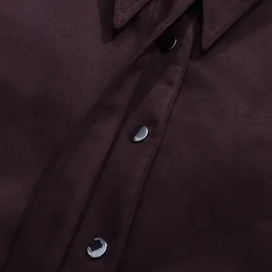 Close-up of burgundy suede-like fabric and black buttons on a stylish collar shirt