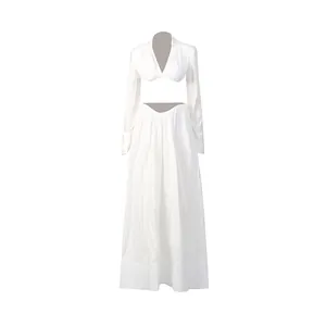 Ensemble deux pièces blanc élégant avec haut court décolleté en V et jupe longue plissée.