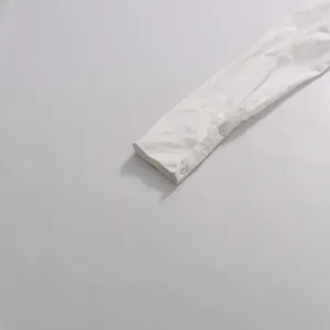 Gros plan de la manchette d'une manche longue blanche avec trois boutons ronds