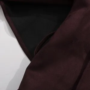 Close-up of burgundy suede fabric and black lining detail of a French style jacket.
