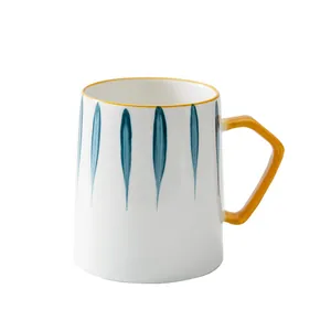 Handbemalte minimalistische Keramiktasse mit blauen Streifen und gelbem Henkel