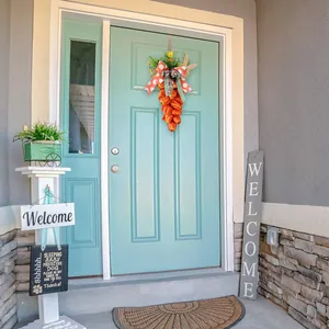 Vibrant orange tulip carrot wreath with ribbons hanging on a light blue door for Easter