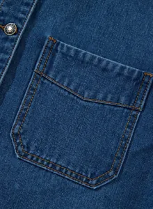Nahaufnahme einer blauen Jeansjackentasche mit kontrastierenden orangefarbenen Nähten und Knopf