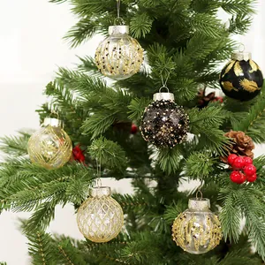 Exquisite schwarz-goldene Weihnachtskugeln hängen an einem grünen Tannenbaum