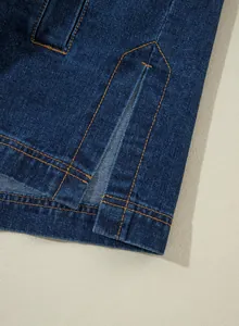 Detaillierte Nahaufnahme des Saums einer blauen Jeansjacke mit seitlichem Schlitz