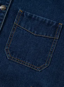 Detailaufnahme der Tasche und des Vintage-Metallknopfes einer dunkelblauen Jeansjacke