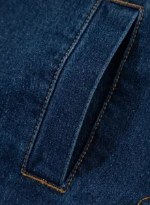 Nahaufnahme einer blauen Jeansjackentasche mit kontrastierenden orangen Nähten.