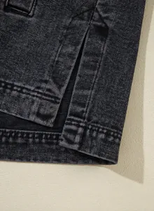Detailansicht des geschlitzten Saums und der Nähte einer schwarzen Damen-Jeansjacke