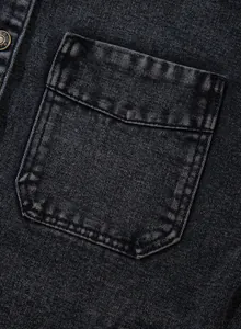 Detaillierte Makroansicht einer funktionellen Pattentasche auf schwarzem Jeansstoff