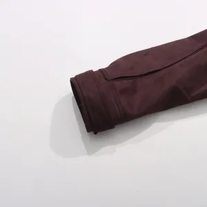 Close-up detail of a burgundy suede-like sleeve cuff with refined stitching and slit