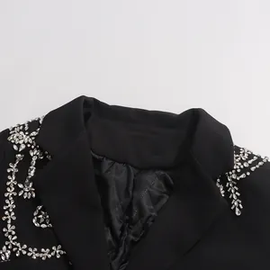 Detailed close-up of luxurious black blazer with intricate silver rhinestone embellishments