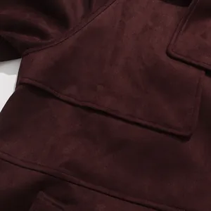 Macro view of burgundy faux suede trench coat detailing the lapel and pocket texture