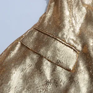 Detailed macro view showing the dense gold sequins and texture of a luxury fashion blazer