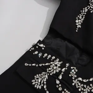 Close-up of elegant black blazer with heavy rhinestone flower pattern and cut-out design