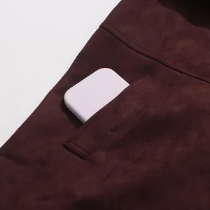Detail of a burgundy suede-like coat featuring a functional side pocket and soft texture.