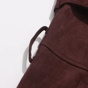 Macro view showing the premium suede texture and belt loop of a burgundy trench coat