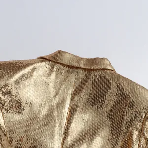Detailed close-up view of a glamorous gold sequined blazer collar and shoulder area