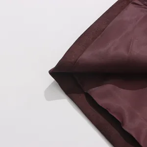 Close-up detail of deep burgundy trench coat lining and outer wool-like fabric texture