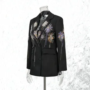 Gros plan d'un blazer noir avec des motifs de feux d'artifice en paillettes complexes.