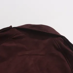 Close-up detail of the collar and shoulder stitching on a burgundy suede trench coat.