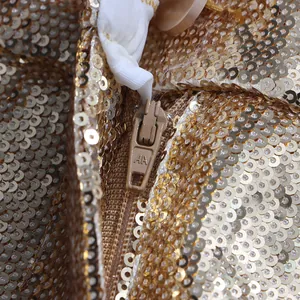 Close-up of gold sequin fabric and matching zipper detail for a fashion-forward suit set.
