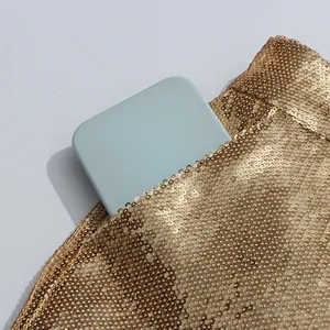 Macro view of gold sequined suit showing pocket detail and shimmering texture for fashion