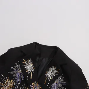 Détail de broderies pailletées feu d'artifice sur une veste de blazer noire avec col en V chic