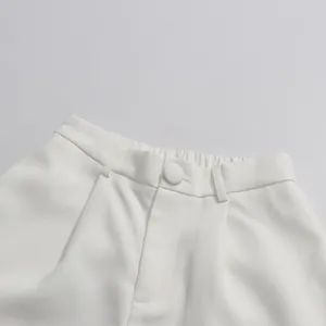 Detailed view of white high waist straight pants showing button and elastic waistband.