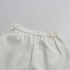 Close-up detail view of elegant white high-waisted straight-leg pants with elastic waistband