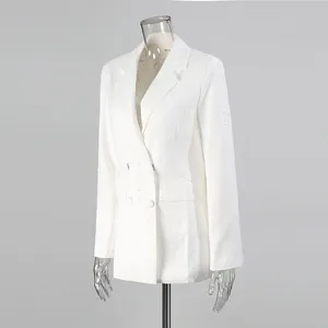 Detail of elegant white blazer featuring intricate pearl embellishments and classic lapel