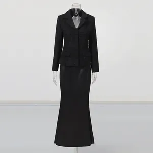 Elegant black tweed blazer and long fishtail skirt two-piece set on mannequin display.