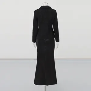 Back view of women's black tweed jacket and elegant long satin skirt two-piece set