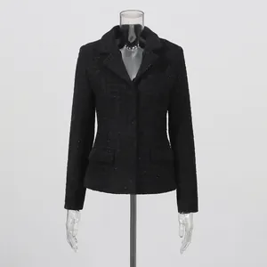 Close-up of elegant black tweed jacket with lapel collar and waist-slimming fit