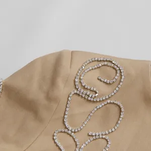 Dettaglio della decorazione in strass su un elegante top corto di colore kaki.