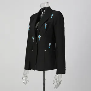 Detail view of black women's blazer with elegant blue rhinestone embellishments.