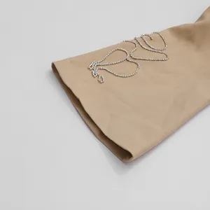 Primo piano di una manica beige con scintillante ricamo 'Love' in strass di lusso.