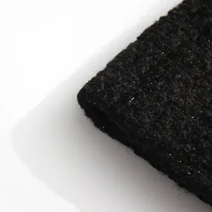 Macro detail of high-quality black tweed fabric with a subtle silver metallic shimmer