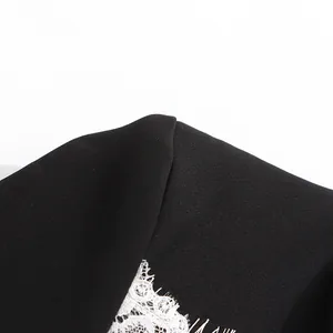 Vue rapprochée de la couture de l'épaule et de la dentelle blanche sur cette veste noire élégante