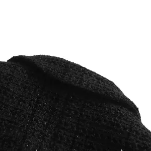 Macro detail of black tweed fabric with subtle shimmer for elegant suit