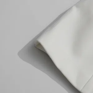 Macro detail of high-quality white blazer fabric showing premium fine twill texture