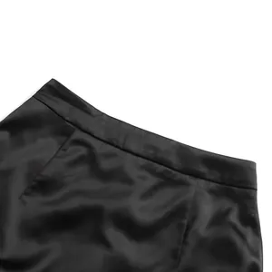Detailed macro view of the black satin high-waisted skirt's waistline stitching.