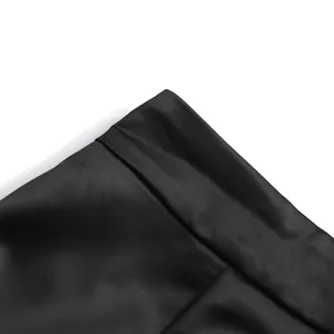 Detailed macro view of the smooth black satin fabric texture from elegant suit set