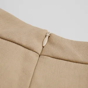 Dettaglio della cerniera nascosta e della vita dei pantaloni eleganti beige